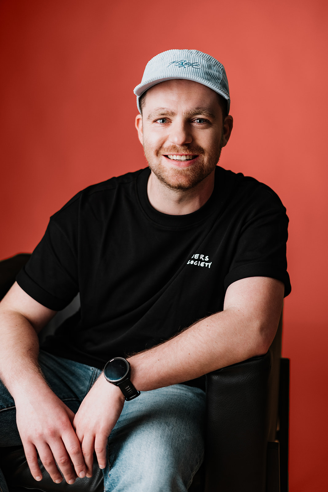 Geschäftsführer Steffen sitzt auf einem Sessel und lacht in die Kamera